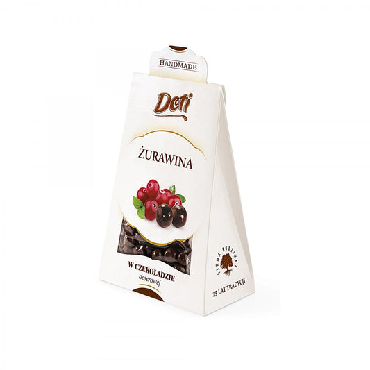 Cranberries in Zartbitterschokolade von DOTI in 100 g Verpackung, Schokoladenüberzogene Beeren auf einem weißen Teller
